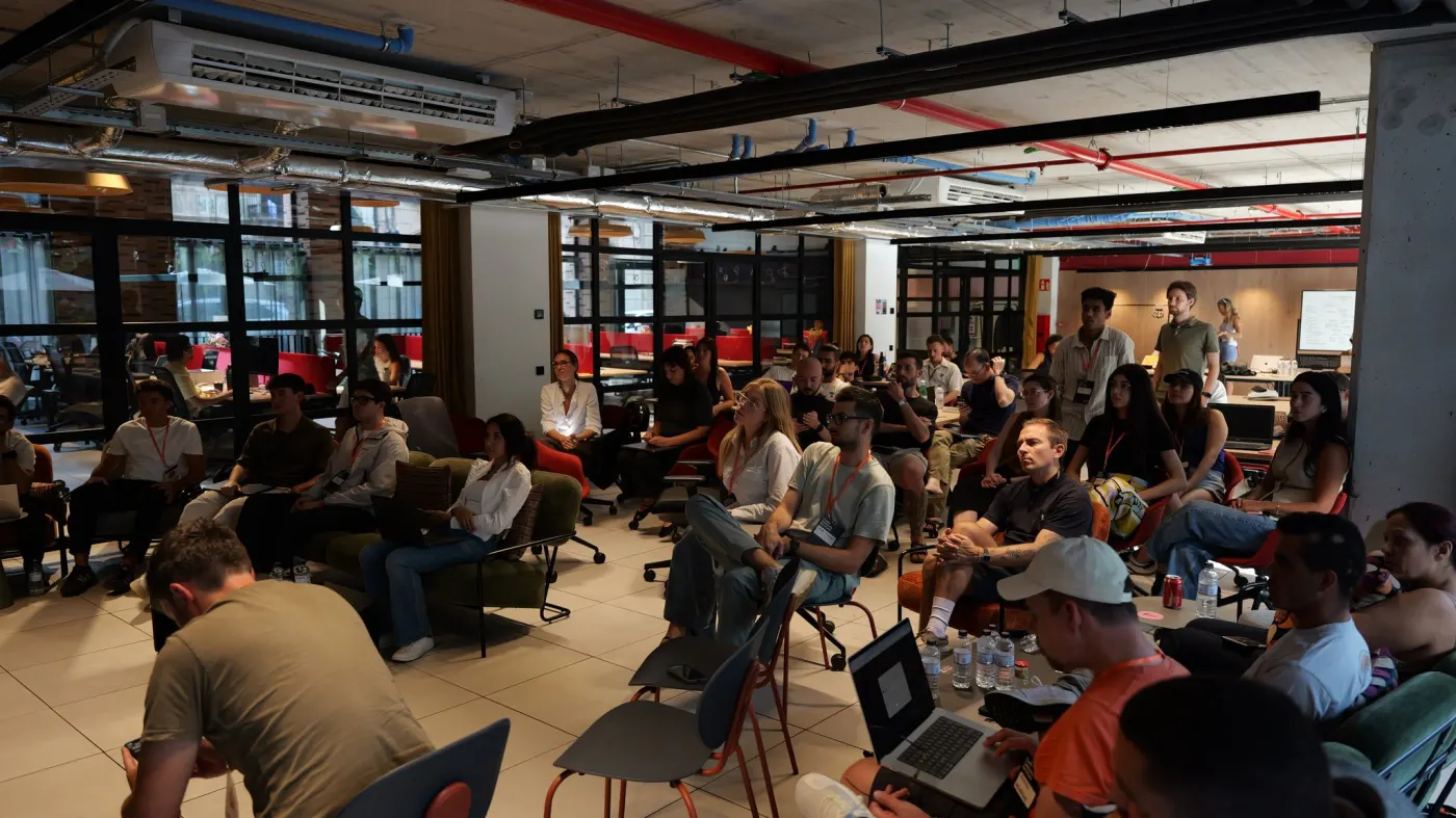 Teams beim Impact Lab hören im offenen Arbeitsbereich einem Briefing zu